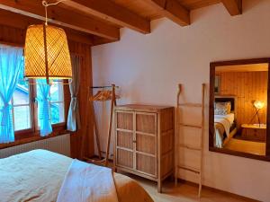 a bedroom with a bed and a mirror at Sawasdee Swiss Chalet Wilderswil in Wilderswil