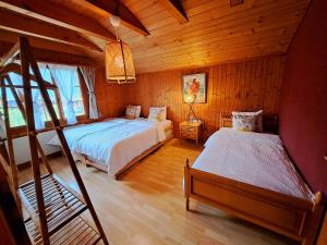 Sawasdee Swiss Chalet Wilderswil في وايلدرسويل: غرفة نوم بسريرين في كابينة خشبية