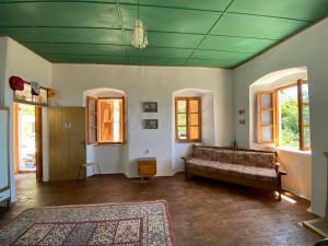 Shotgun Hostel في Vuno: غرفة معيشة مع أريكة وسجادة