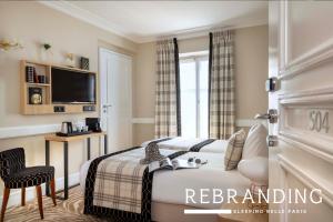 a bedroom with a bed and a television and a chair at Hotel Sleeping Belle in Paris