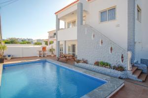 a swimming pool in front of a house at Casa Madeira in Burgau