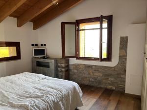 Un dormitorio con una cama y una pared de piedra. en Antico Borgo le Roste, en Sassomorello