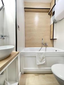 a white bathroom with a tub and a sink at Pastelowe Studio - Comfy Apartments in Gdańsk