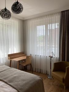 Schlafzimmer mit einem Bett, einem Schreibtisch und einem Fenster in der Unterkunft Willa Witkacy in Słupsk