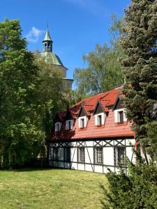 a building with a red roof and a tower at Willa Witkacy in Słupsk