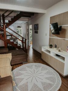 a living room with a staircase and a rug at Pousada Canto do Pescador in Bombinhas