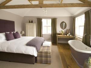 a bedroom with a large bed and a bath tub at The Percy Arms in Guildford