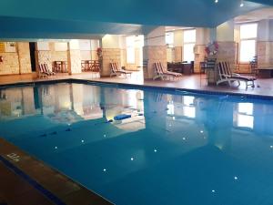 a large swimming pool in a building with chairs at Shafa Abha Hotel in Abha