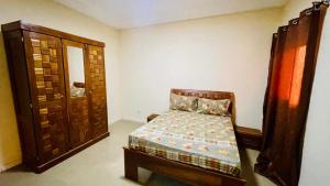 1 dormitorio pequeño con 1 cama y armario en JIKKE Appartement, en Dakar