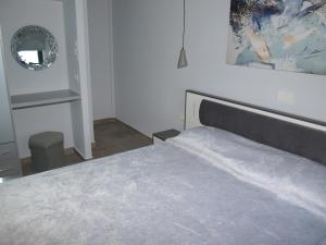 a bedroom with a bed and a mirror on the wall at Attic Apartments in Agia Anna