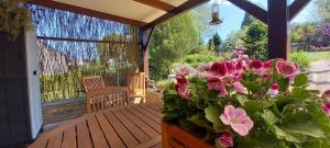 Eine Veranda mit rosa Blumen drauf. in der Unterkunft Gîte Les Sittelles in Tenneville