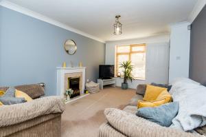 a living room with two couches and a fireplace at Cosy Contractor House & Garden & Free Parking in Swindon