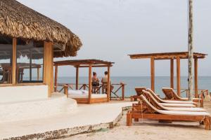 duas pessoas sentadas na praia num resort em Hotel Sunsets del Rosario em Isla Grande