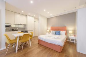 a bedroom with a bed and a table and chairs at Braga Center Apartments - Eça de Queirós in Braga