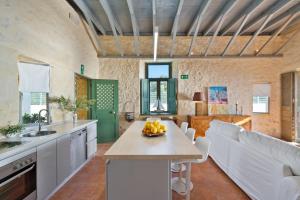 a kitchen with a table with a bowl of fruit on it at Villa Mediterranea, with heated pool in Livadia