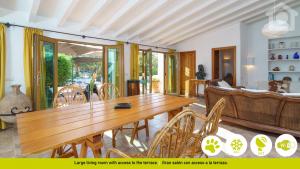 a dining room with a wooden table and chairs at SolHabitat Villa La Andana in Benissa