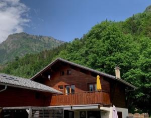 a wooden house with a balcony in front of a mountain at Appartement avec jacuzzi dans chalet privé, grande terrasse, parking gratuit in Les Houches