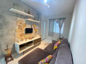 a living room with a couch and a tv at Casa 181 Alto do Moura in Caruaru