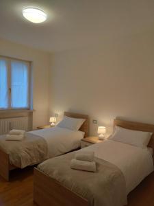 dwa łóżka siedzące obok siebie w sypialni w obiekcie Appartamento nel verde circondato dalle montagne w mieście Vo Sinistro