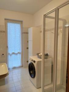 a washing machine in a bathroom with a shower at Appartamento nel verde circondato dalle montagne in Vo Sinistro