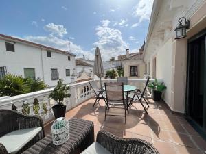 a patio with chairs and a table on a balcony at Puerta del Agua in Uclés