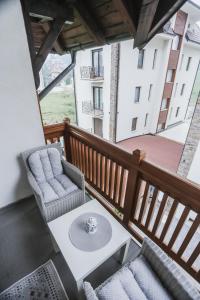 a balcony with two chairs and a coffee table at Apartmani Zračak in Zlatibor