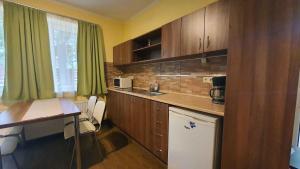 une cuisine avec des placards en bois, une table et un bureau dans l'établissement Apartment in Siofok/Balaton 19746, à Siófok