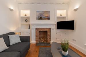 a living room with a couch and a fireplace at Falcon House in Pembroke Dock