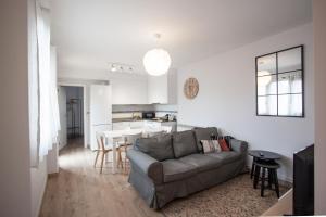uma sala de estar com um sofá cinzento e uma cozinha em La Meruxa, adosado a 2 km de la playa em Llanes
