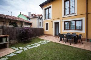 a patio with a table and chairs in a yard at La Meruxa, adosado a 2 km de la playa VV-2244-AS in Llanes