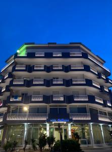 a tall building with a green sign on it at Hotel Bellevue in Caorle