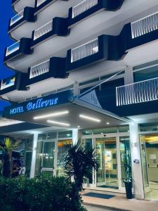 un edificio de hotel con signos azules y blancos en él en Hotel Bellevue, en Caorle