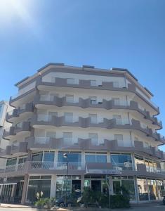 un edificio de apartamentos alto con muchas ventanas en Hotel Bellevue, en Caorle