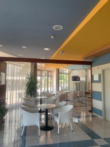 a restaurant with white chairs and tables in a building at Hotel Bellevue in Caorle