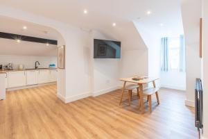 a kitchen and dining room with a table at Banc Apartment 2 in Porthmadog