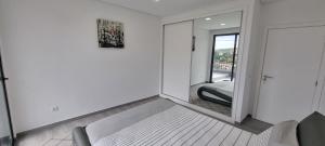 Habitación blanca con espejo y silla en Villa Castanho I, en Calheta