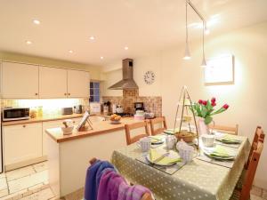 a kitchen and dining room with a table and chairs at Fox Hat Cottage in Newton Abbot +12 photos