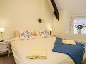 a white bed in a room with a window at Fox Hat Cottage in Newton Abbot