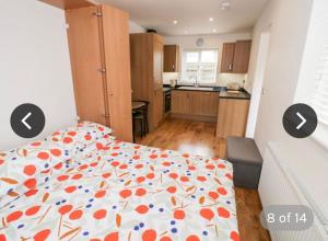 a bedroom with a bed with an orange and blue comforter at The Lodge in Eckington