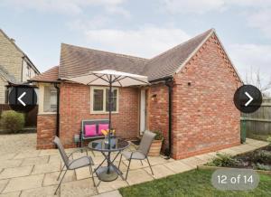 a brick house with a patio with a table and chairs at The Lodge in Eckington