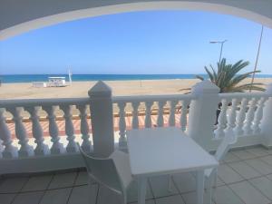 a white table on a balcony with a view of the beach at Bahía Serena in Roquetas de Mar
