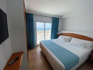 a bedroom with a bed and a view of the ocean at Bahía Serena in Roquetas de Mar