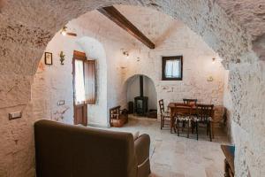 een woonkamer met een tafel in een stenen gebouw bij Incantevoli Trulli Tiche in Cisternino