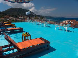 een zwembad met tafels en stoelen bovenop een resort bij Corfu Star Apartments in Benitses