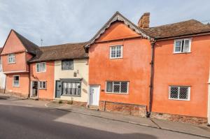 an orange house on the side of a street at Extraordinary 15th Century timber framed cottage in famous Medieval village - The Tryst in Lavenham