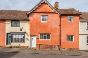 an orange house on a street at Extraordinary 15th Century timber framed cottage in famous Medieval village - The Tryst in Lavenham