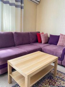 a living room with a purple couch and a coffee table at AL BARAKA in Borovoye