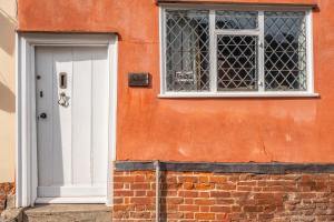 a white door and a window on a building at Extraordinary 15th Century timber framed cottage in famous Medieval village - The Tryst in Lavenham +46 photos