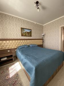 a bedroom with a blue bed and a ceiling fan at AL BARAKA in Borovoye