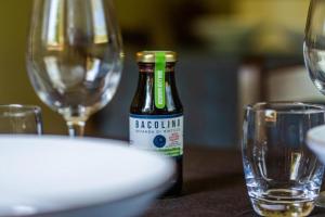 a bottle of wine sitting on a table with glasses at Villaggio Anemone - Chalet Anemone in Capanne di Sillano +22 photos